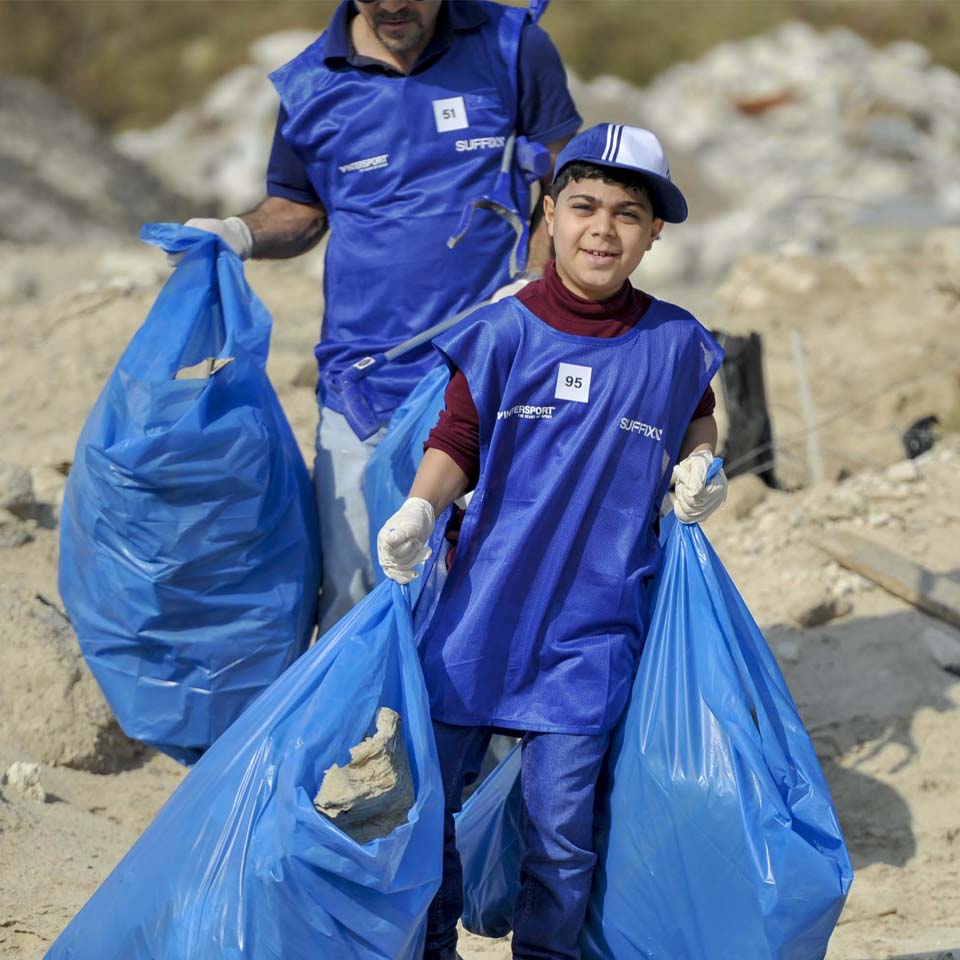 Desert cleanup volunteers in purple shirts walking across desert terrain