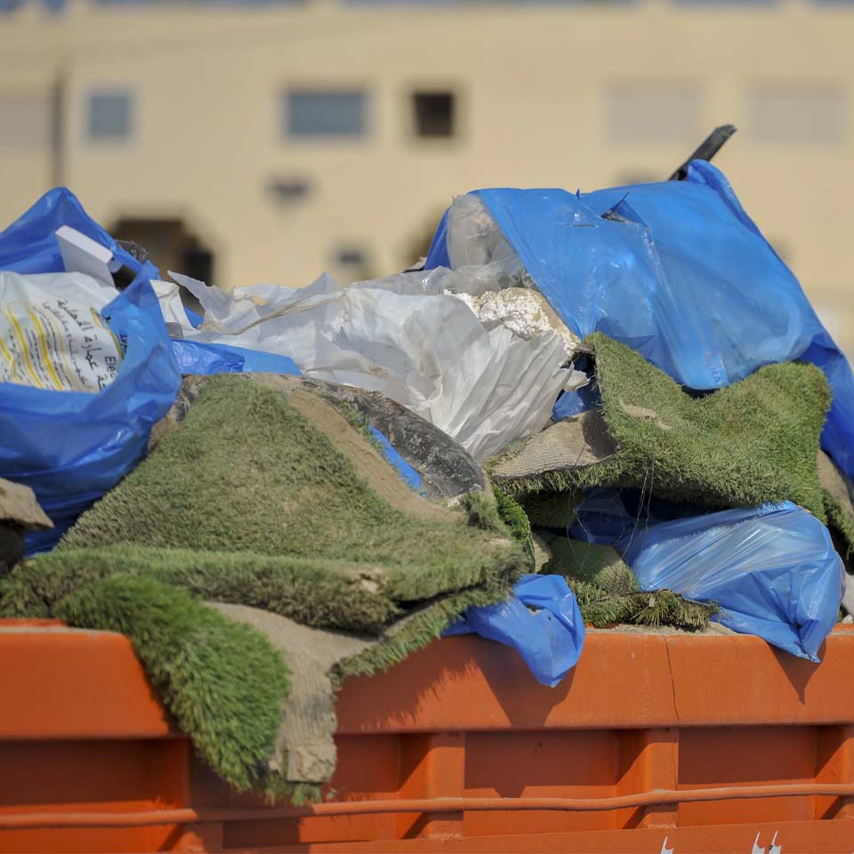 Desert landscape with cleanup volunteers and collection points visible in distance