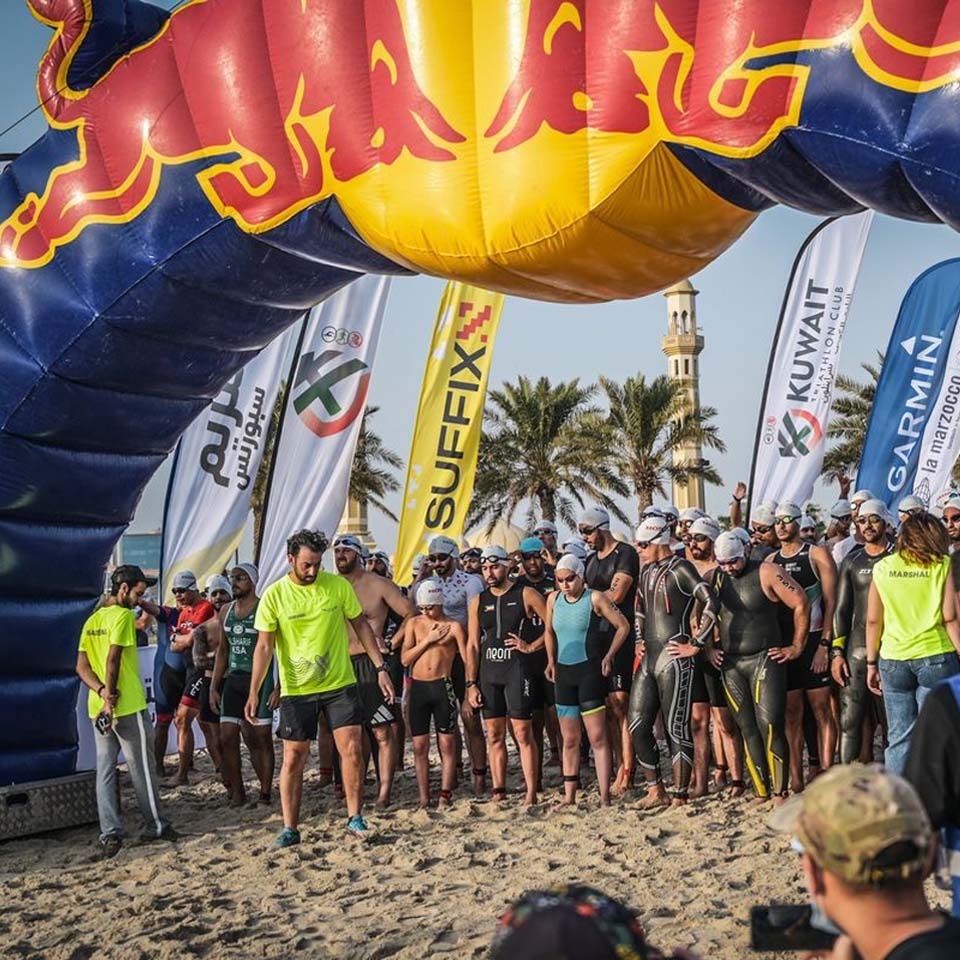 Volunteers in purple shirts carrying large bags of collected desert waste