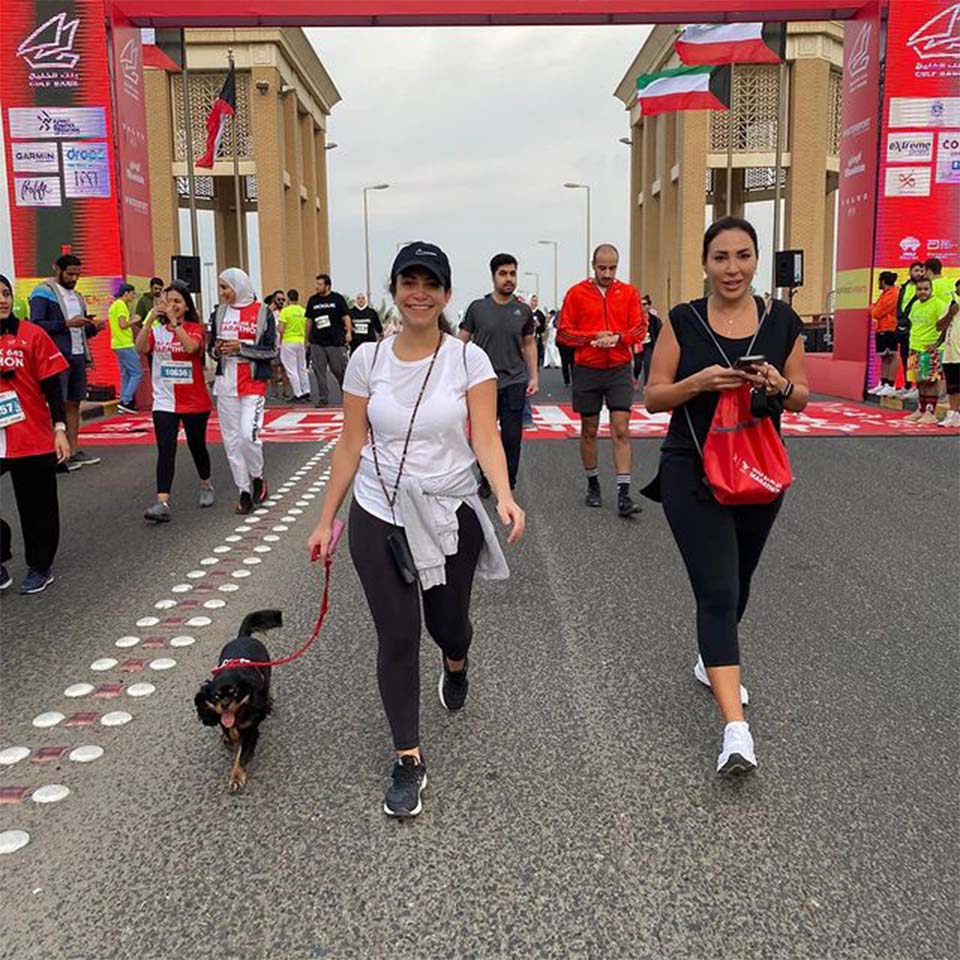 Desert cleanup volunteers in purple shirts walking across desert terrain